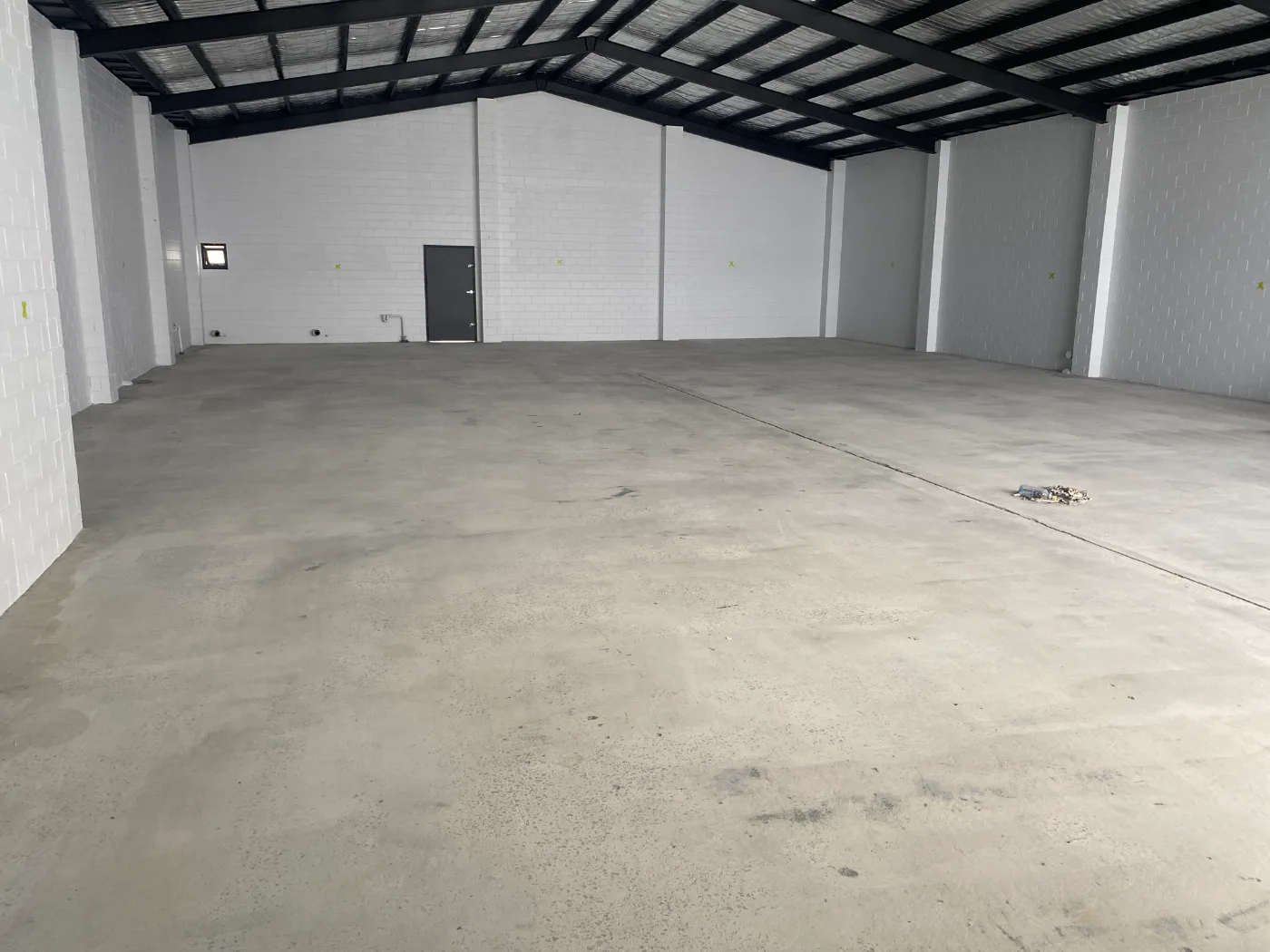 Warehouse slab with walls and beams repainted, concrete bare and ready for the epoxy coating