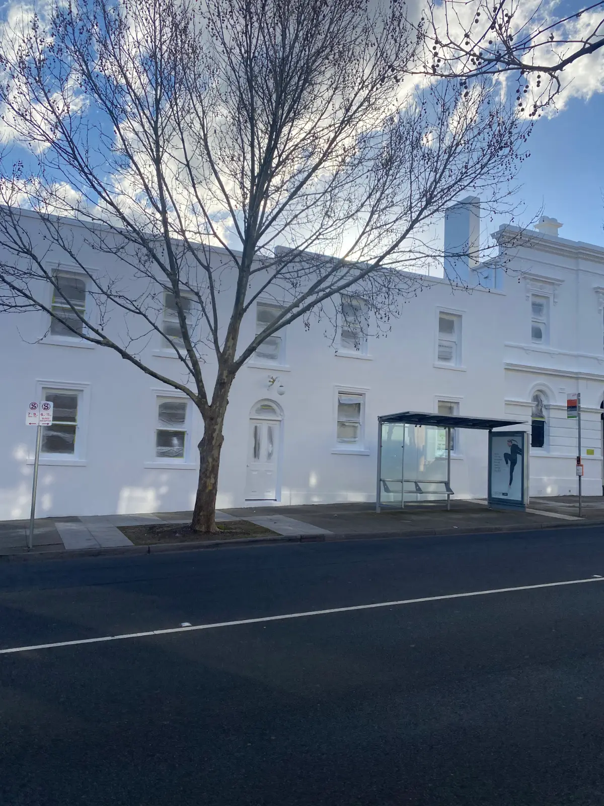 The completed white rendered facade of a High Street Armadale commercial building after repainting by Jetblack Painting