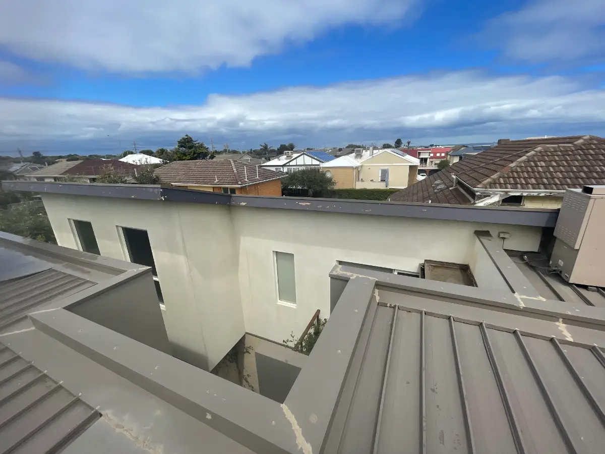 Roofline of a completed Aspendale exterior repaint with Port Phillip Bay beyond