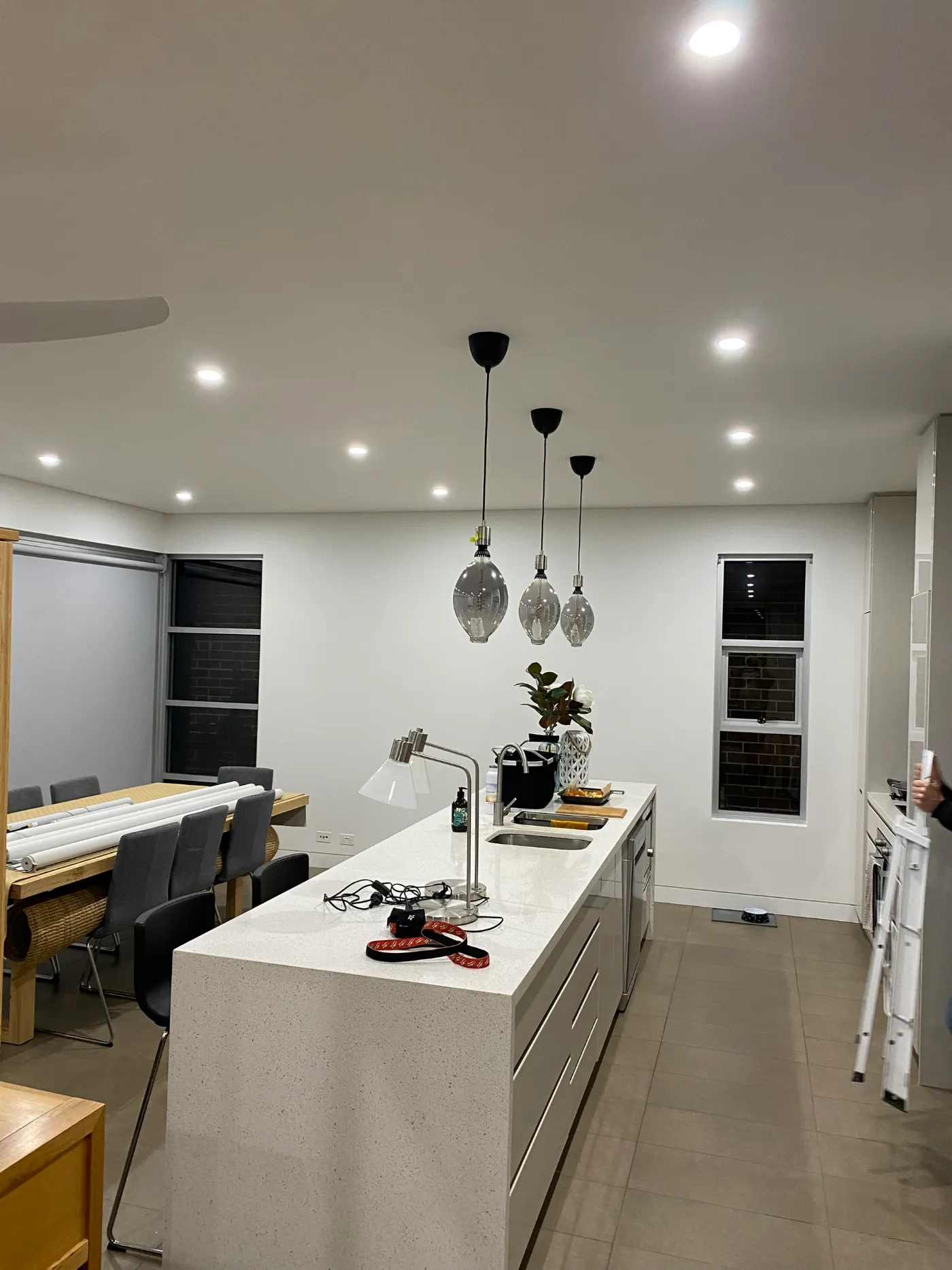 Kitchen and dining area in the same Black Rock home after painting, with white walls and ceiling above the existing cabinetry and dining table