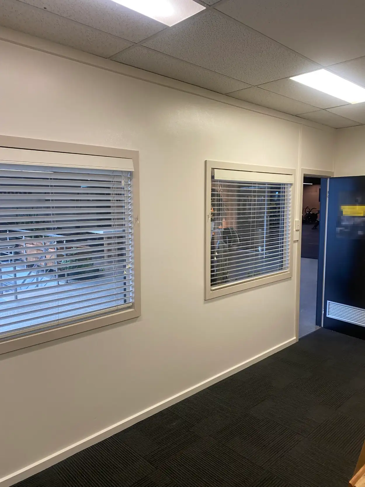 Commercial office wall in Brighton East after interior painting, off-white with internal window surrounds in a deeper stone tone and white skirting