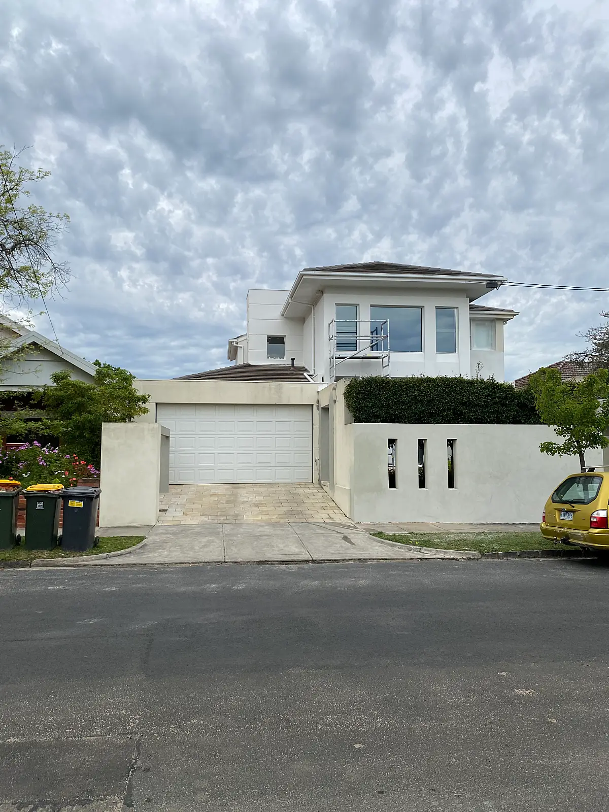 Rendered two-storey Caulfield home with scaffolding in place before an exterior repaint