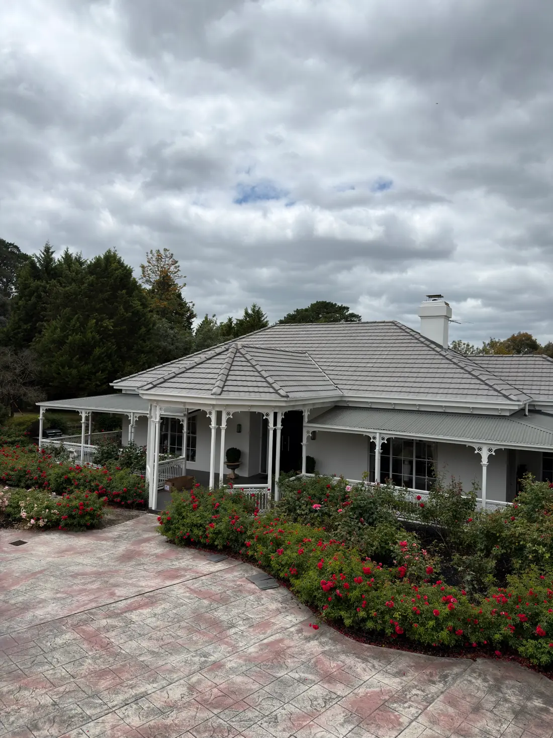 The same Donvale home after roof restoration, with a uniform light grey-taupe tile roof and the ridge capping repaired
