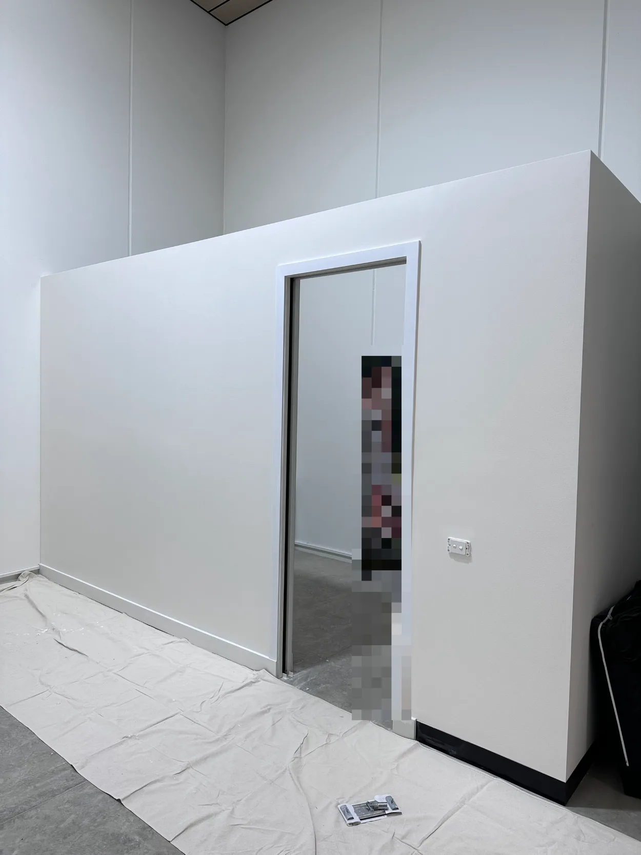 A new partition room in a Highett commercial fitout, walls, door frame and skirting finished in white, with canvas drop sheets along the floor