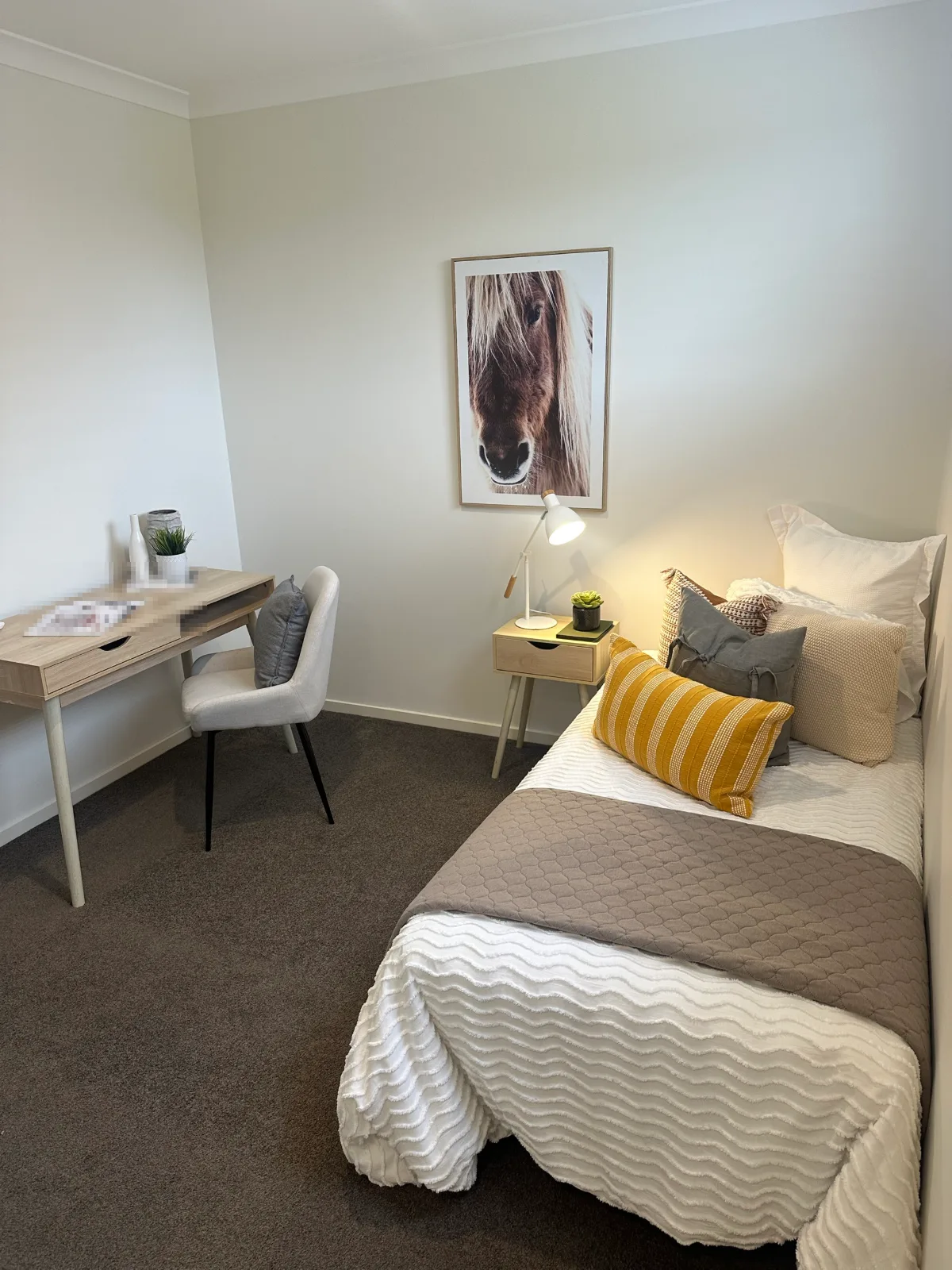 Small bedroom in a Keysborough home after interior painting, pale walls and white ceiling, cornice and skirting, furnished with a single bed, a desk and a framed print