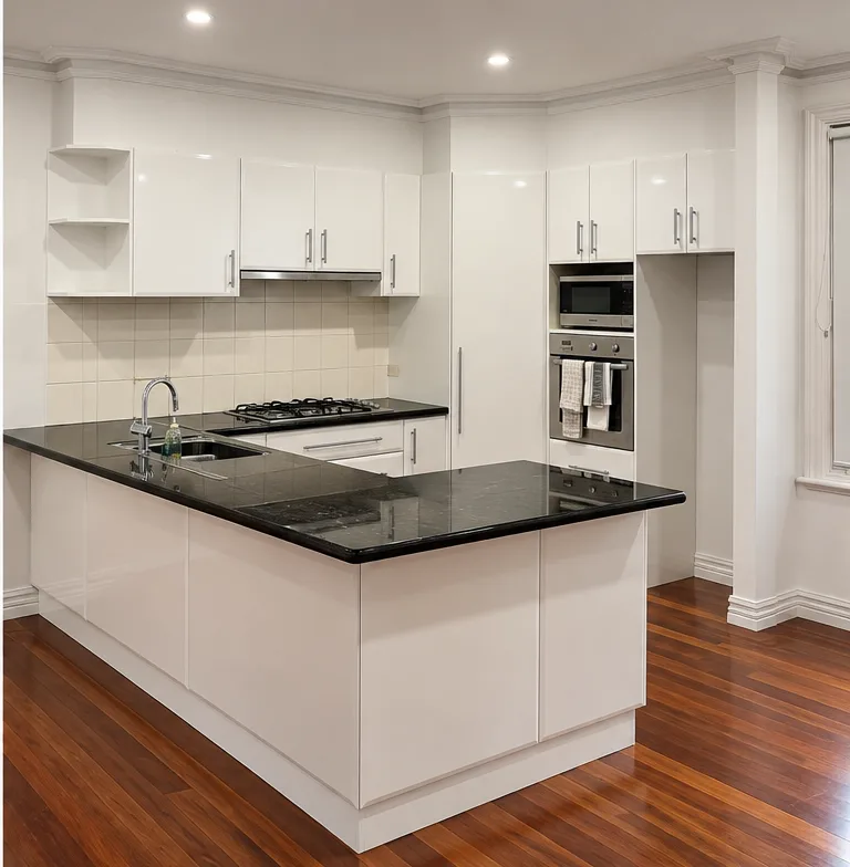 The same Malvern kitchen after resurfacing, doors rehung in a white gloss finish with the original black benchtop and cream tiled splashback untouched