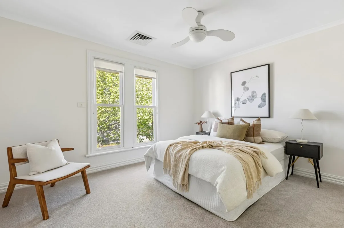 The same Malvern bedroom after the pre-sale repaint, white walls, ceiling, cornice and double-hung window frames above grey carpet
