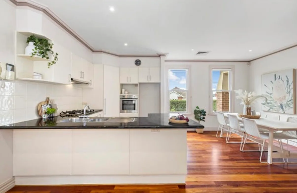 Kitchen in a Malvern home before the pre-sale repaint, with mauve cornices and trim against white walls