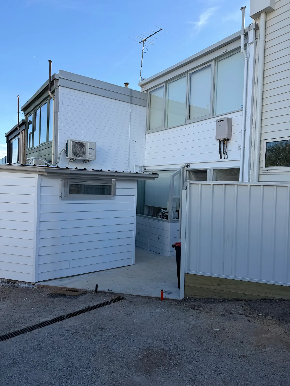 The same Mordialloc rear elevation after painting, with the brick, weatherboard and new cladding all finished in white