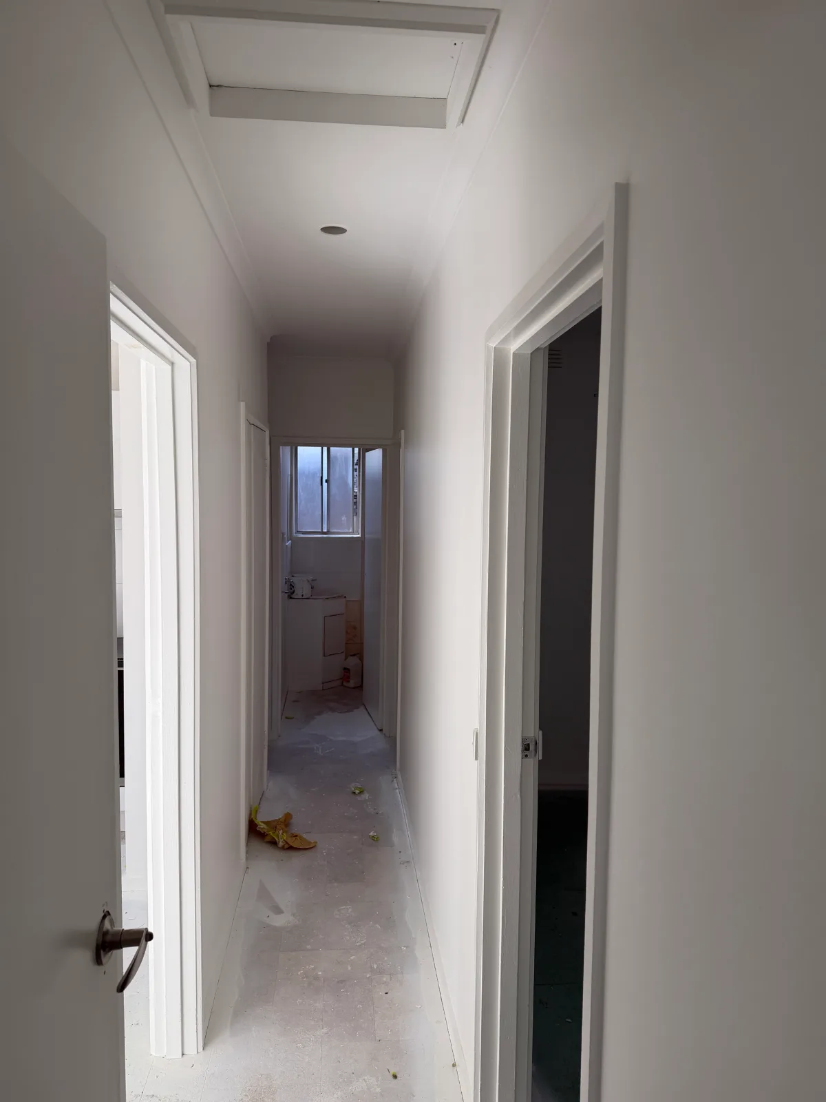 The same Mordialloc rental's hallway looking the other way toward the laundry, walls, ceiling and door frames freshly painted white