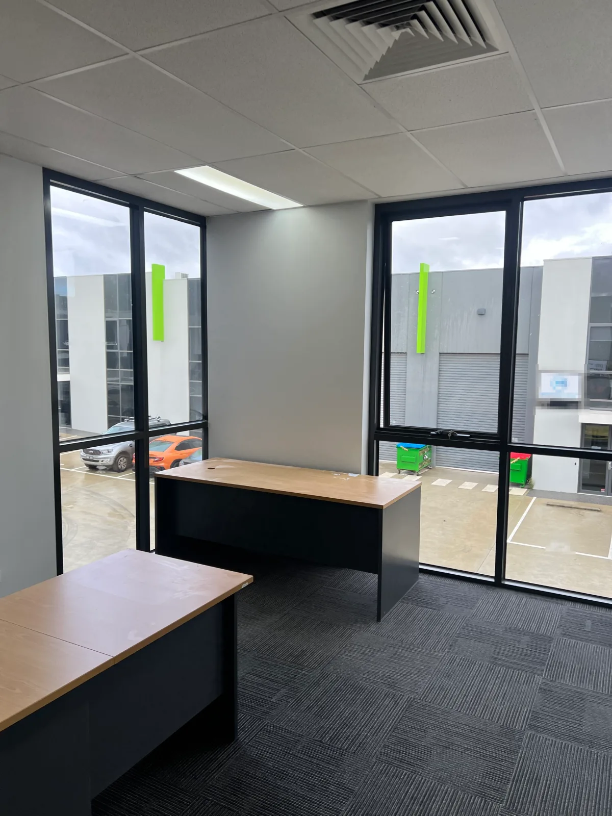 Corner office in a Chadstone commercial fitout painted by Jetblack Painting, showing finished window reveals and wall surfaces between full-height glazing