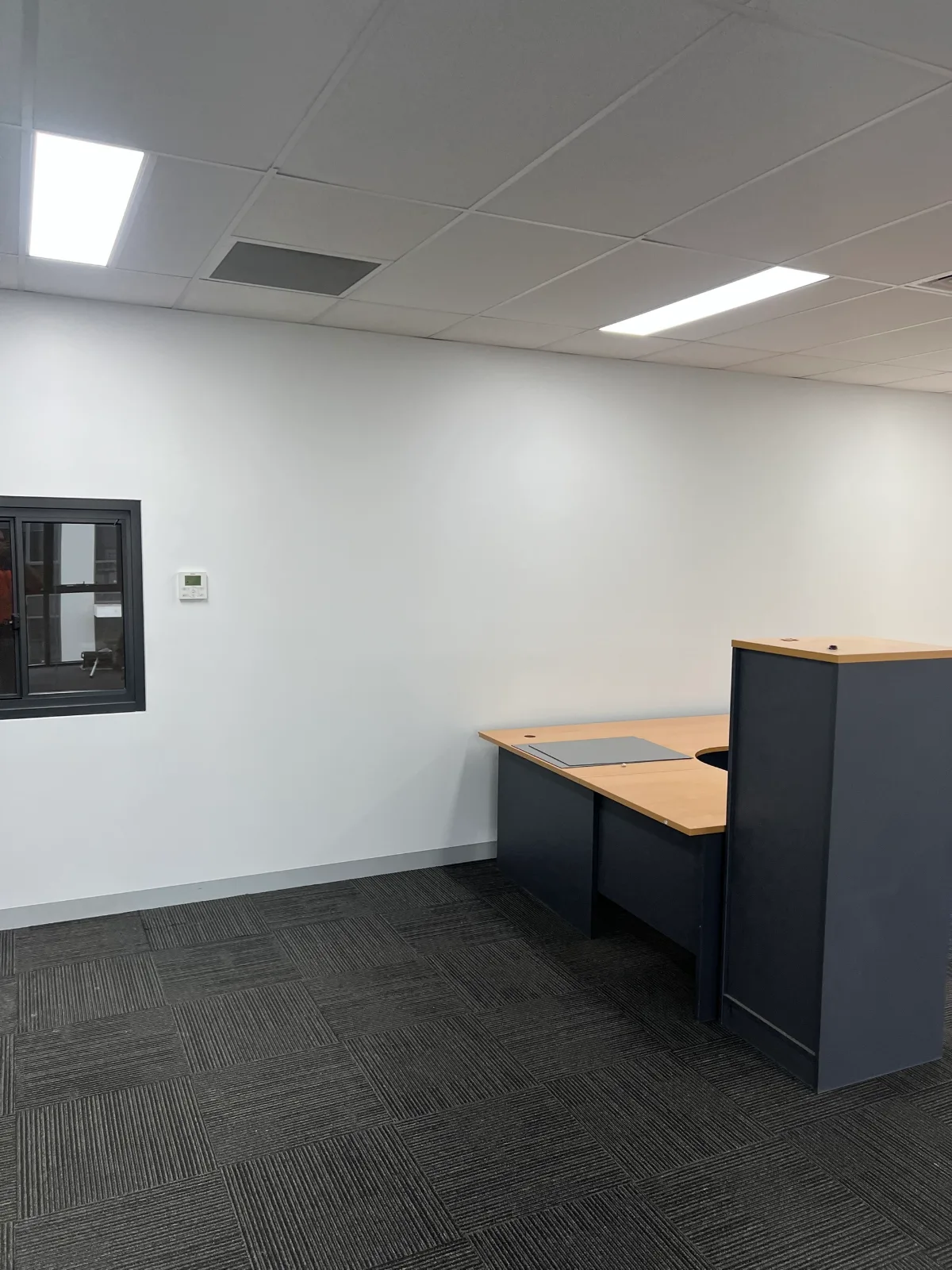 Open office room in a Chadstone commercial fitout painted by Jetblack Painting, with a continuous wall run finished to the ceiling grid and skirting line