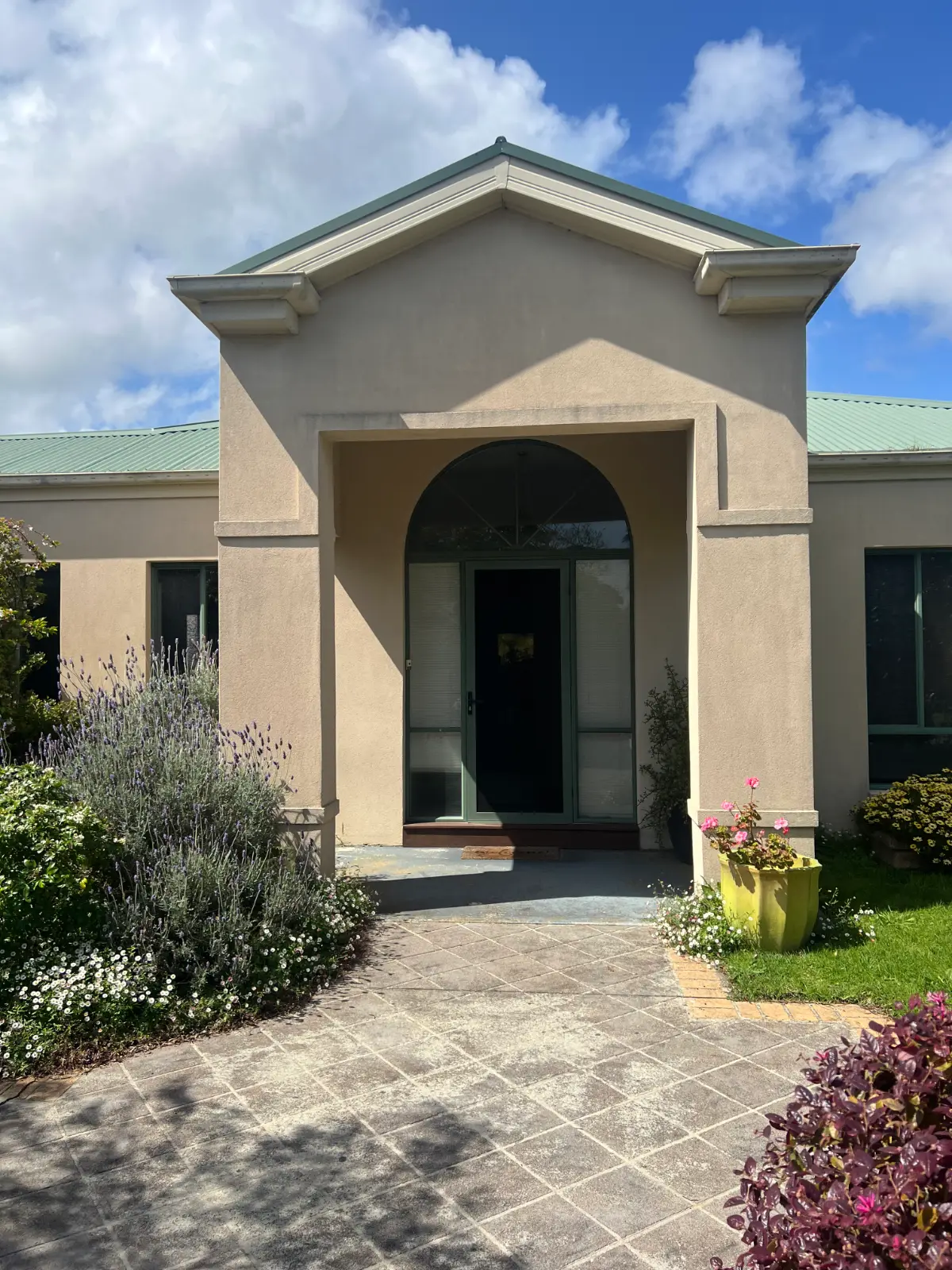 Cream rendered entry and green Colorbond roof of a Safety Beach home before repainting